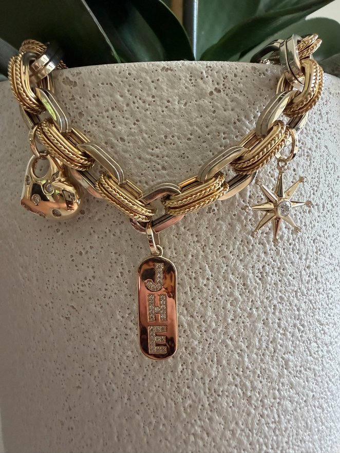 Gold charm bracelet with a starburst charm