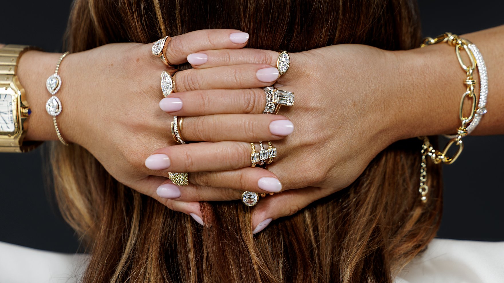 Hands with stacked diamond rings and bracelets